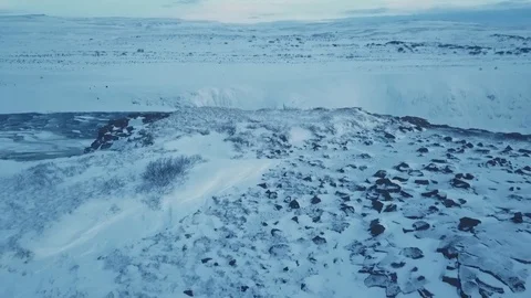 Aerial View Flying Over Mountain Cliff To Reveal Rushing Water Below In Winter Stock Footage 87247996