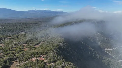 Aerial view flying over mountain peaks in clouds near Poulithra Greece with mist Video stock 302069858