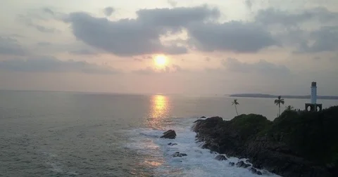 Aerial view flying over the ocean cliffs and lighthouse at sunset in Sri Lanka Vidéo 79724503