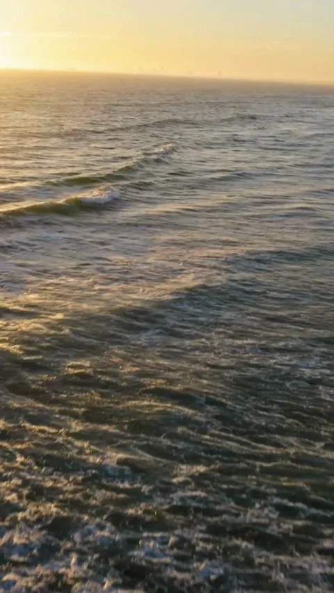 Aerial view flying over ocean waves crashing on sandy Vídeo Stock 333158904
