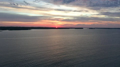 Aerial view flying over open water sea toward sunset in horizon Stock Footage 142136495