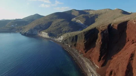 Aerial view flying over red beach on Santorini Greece 4K Stock Footage 56941452