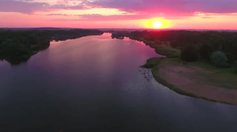 Aerial View. Flying over the river green trees at sunset with sun. Stock Footage 63836848