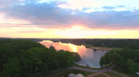 Aerial View. Flying over the river green trees at sunset with sun. Stock Footage 64028766