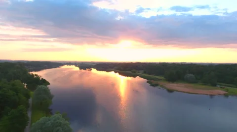Aerial View. Flying over the river green trees at sunset with sun. Stock Footage 64029410