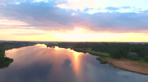 Aerial View. Flying over the river green trees at sunset with sun. Stock Footage 64029762