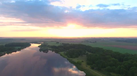 Aerial View. Flying over the river green trees at sunset with sun. Stock Footage 64029805
