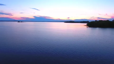Aerial View. Flying over the river green trees at sunset with sun. Stock Footage 64034806