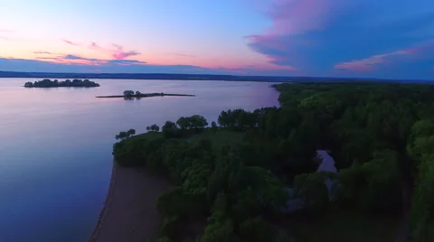 Aerial View. Flying over the river green trees at sunset with sun. Stock Footage 64035059