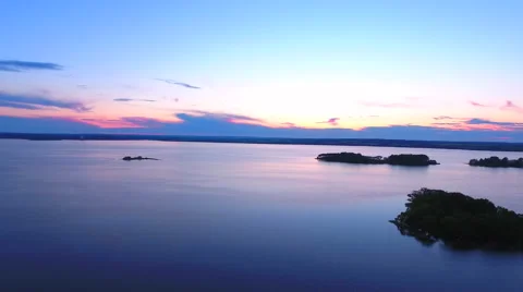 Aerial View. Flying over the river green trees at sunset with sun. Stock Footage 64035111