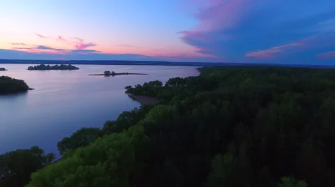 Aerial View. Flying over the river green trees at sunset with sun. Stock Footage 64035171