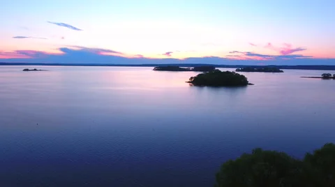 Aerial View. Flying over the river green trees at sunset with sun. Stock Footage 64035232