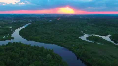 Aerial View. Flying over the river green trees at sunset with sun. Stock Footage 64960450