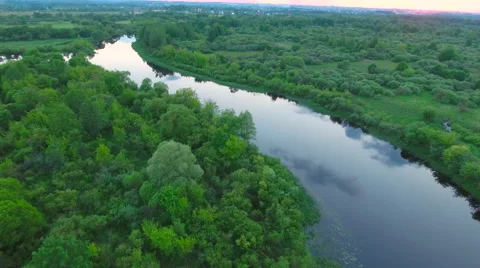Aerial View. Flying over the river green trees at sunset with sun. Stock Footage 64961945