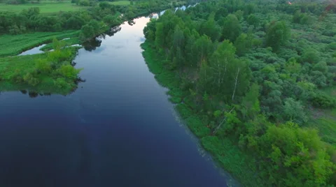 Aerial View. Flying over the river green trees at sunset with sun. Stock Footage 64962461