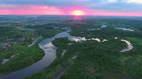 Aerial View. Flying over the river green trees at sunset with sun. Stock Footage 64963196