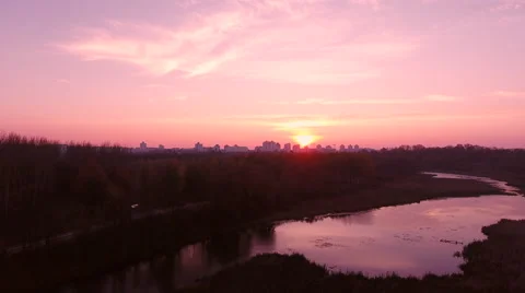 Aerial View. Flying over the river green trees at sunset with sun. Stock Footage 68852736
