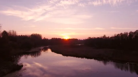 Aerial View. Flying over the river green trees at sunset with sun. Stock Footage 68853280