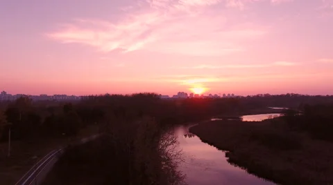 Aerial View. Flying over the river green trees at sunset with sun. Stock Footage 68853496