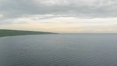 Aerial view flying over river estuary with green hills on background on cloudy Stock Footage 194475575