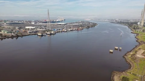 Aerial view flying over a river toward a busy industrial port Video stock 339304726
