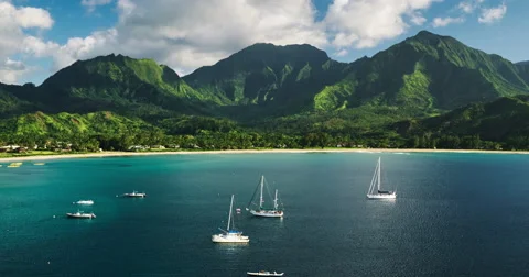 Aerial view flying over sail boats in Hanalei Bay towards beautiful green mou Stock Footage 63229901