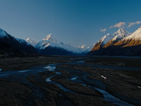 Aerial view flying over snow melt rivers towards snowy mountain peaks in New  Stock Footage 80273164