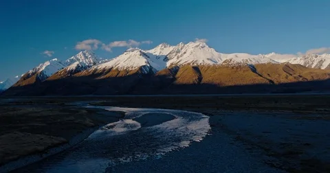 Aerial view flying over snow melt rivers towards snowy mountain peaks in New  Stock Footage 80273184