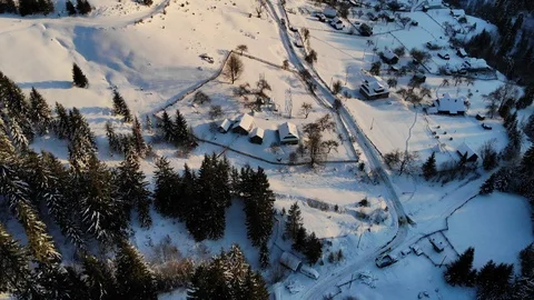 Aerial view flying over snow covered town towards the winter evening. Video stock 124425672