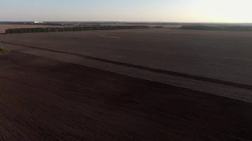 Aerial view flying over the top of a combine harvester and tractor in a field Stock Footage 85695799