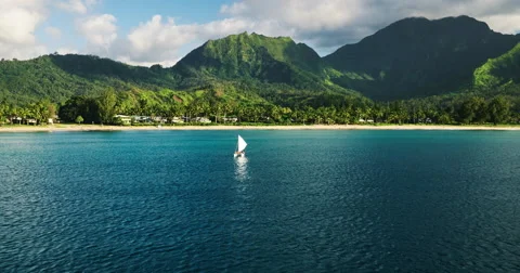 Aerial view flying over tropical blue ocean towards beautiful green mountains Stock Footage 63572671