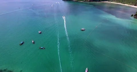 Aerial view flying over tropical lagoon with longtail boats towards beautiful Stock Footage