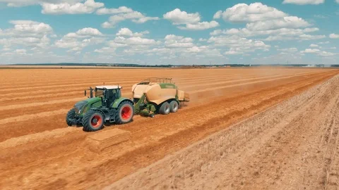 Aerial view flying over wheat field and combine harvester tractor with trailer Stock Footage 94253288