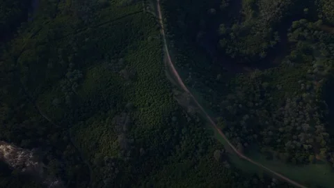 Aerial view flying over winding country road and forest trees Stockbeeldmateriaal 334843549