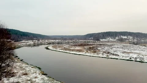 Aerial view flying river with surrounding snowy forest Stock Footage 330272542