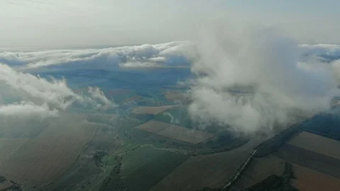 Aerial view, flying through the clouds above countryside scenery morning foggy Stock Footage 112864251
