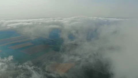 Aerial view, flying through the clouds above countryside scenery morning foggy Stock Footage 112865017