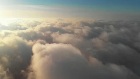 Aerial view flying through clouds at gold colored sunset. Real sky. The concept Stock Footage 157850896