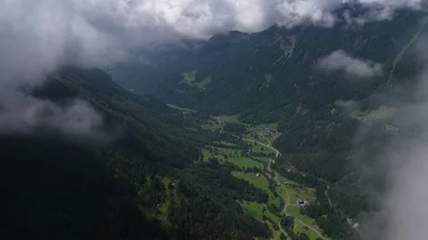 Aerial view flying through clouds over a green mountain valley Video stock 317719888