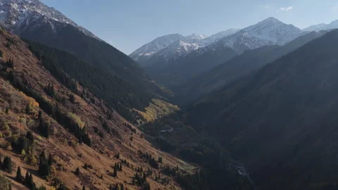 Aerial view flying through a deep mountain valley in autumn, Kazakhstan Видео 344099977