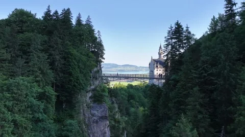 Aerial view flying through a valley revealing neuschwanstein castle Stock Footage 318751844