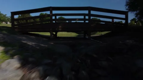 Aerial view flying under small bridge over water Stock Footage 221961456