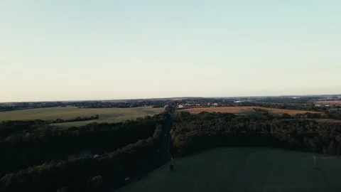 Aerial view flyover of fields and trees towards town during sunset Stock Footage 161074797