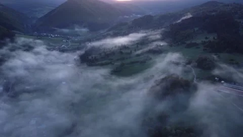 Aerial view of fog in the valley with forests, meadows and houses by the road Video stock 196986471