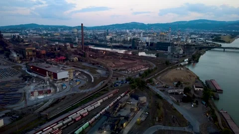 Aerial view following a freight train through a steelworks at dawn Stock Footage 342392548