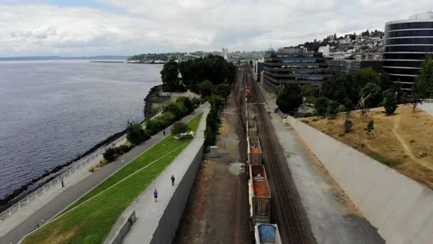 Aerial View Following Train Through City and Park with Runners Stock Footage 142303228
