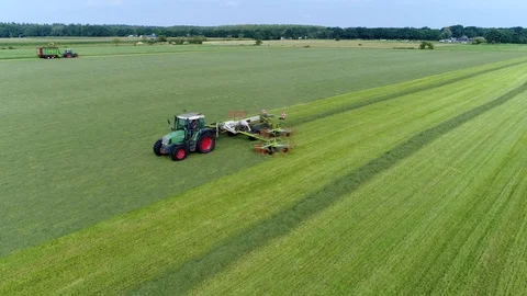 Aerial view footage of tractor creating windrows of grass for silage 4k Stock Footage 123205461