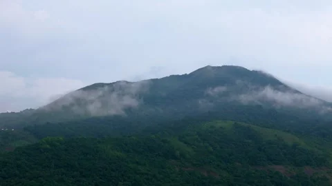 Aerial View of Forest Covered Mountain Surrounded by Low Clouds and Mist Stock Footage 341309430