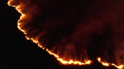 Aerial view of a forest fire at night, heavy smoke causes air pollution, and Stock Footage 263885099