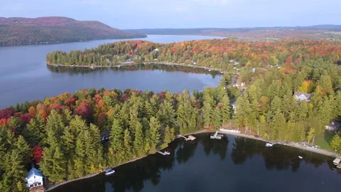 Aerial view of forested lake area with fall color foliage and cabin piers Vídeos de archivo 231355341